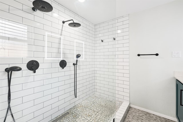 bathroom with vanity and a tile shower