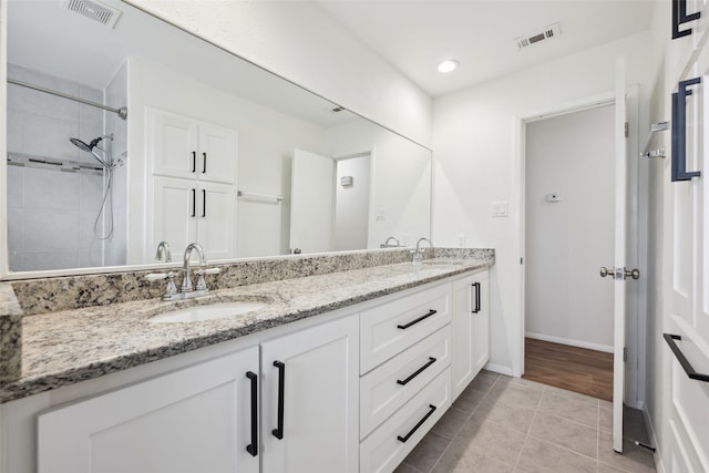 bathroom featuring tile patterned floors, vanity, and a tile shower