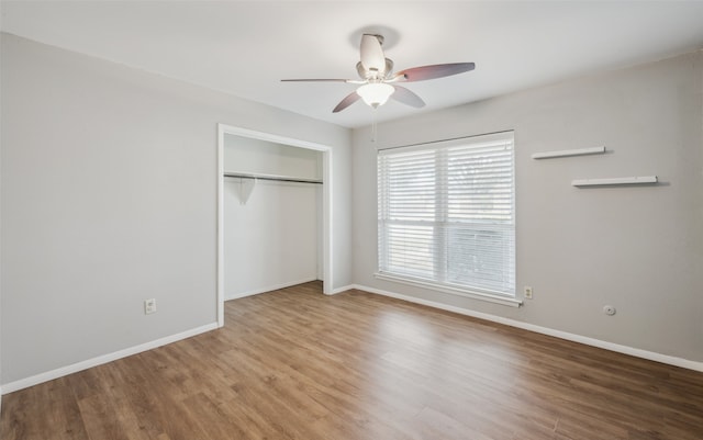 unfurnished bedroom featuring wood-type flooring, a closet, and ceiling fan