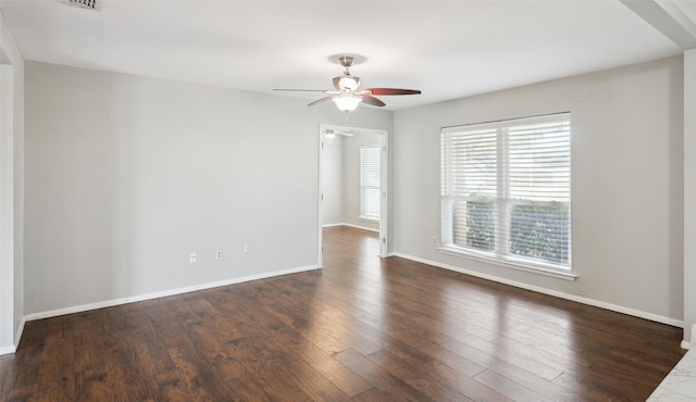 spare room featuring dark wood-type flooring and ceiling fan