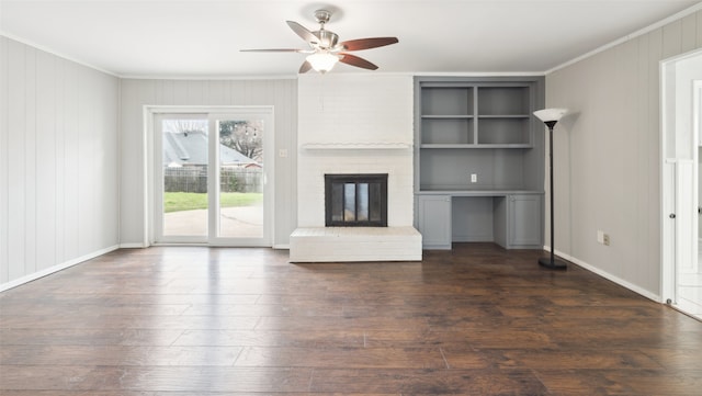 unfurnished living room with dark wood-type flooring, ceiling fan, ornamental molding, and a brick fireplace