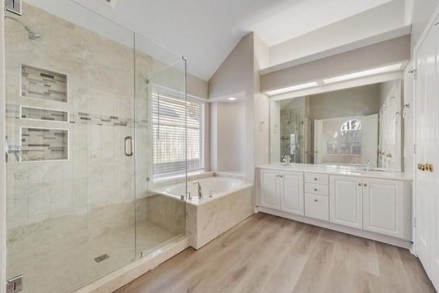 bathroom with hardwood / wood-style flooring, vanity, and shower with separate bathtub