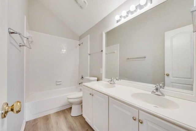 full bathroom featuring vanity, vaulted ceiling, bathing tub / shower combination, hardwood / wood-style floors, and toilet