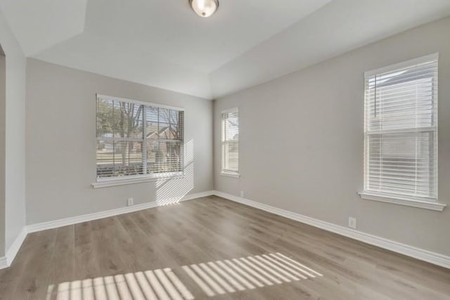 unfurnished room with wood-type flooring and lofted ceiling