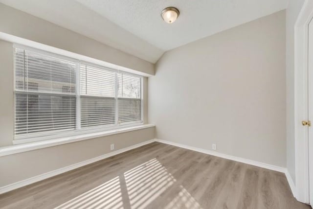 unfurnished room with lofted ceiling and hardwood / wood-style flooring