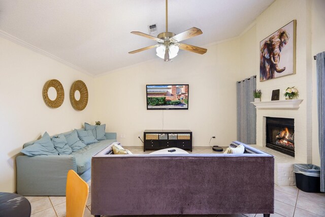 living room with ornamental molding, vaulted ceiling, ceiling fan, light tile patterned floors, and a fireplace