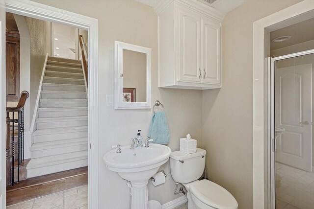 bathroom with a shower with door and toilet