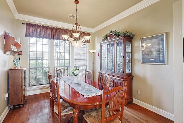 dining space featuring dark hardwood / wood-style flooring, ornamental molding, and an inviting chandelier