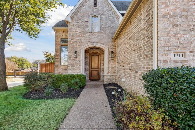 property entrance featuring a lawn