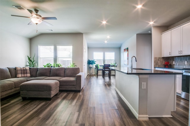 living room with dark hardwood / wood-style floors, ceiling fan, sink, and vaulted ceiling