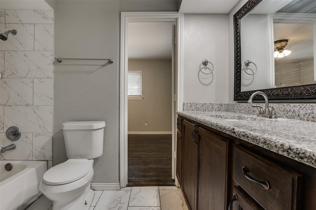 full bathroom with toilet, vanity, and tiled shower / bath