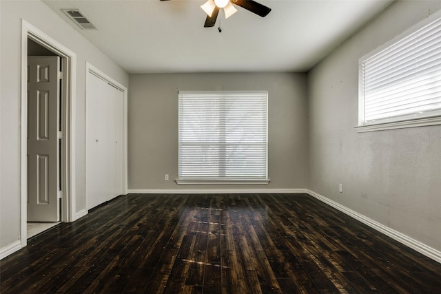 unfurnished room featuring ceiling fan and dark wood-type flooring