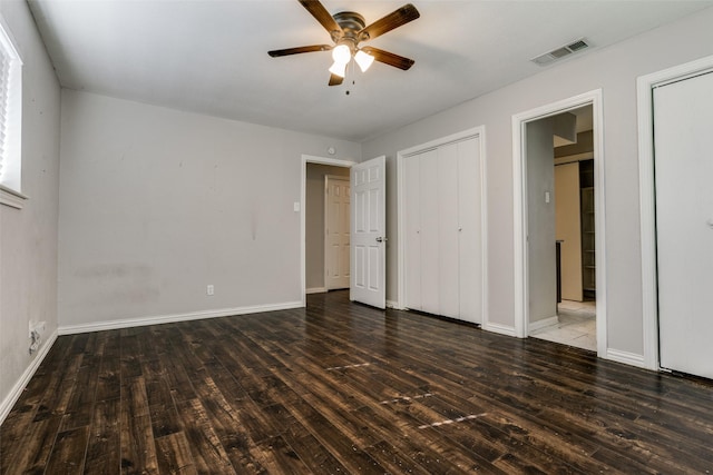 unfurnished bedroom with ceiling fan and dark wood-type flooring