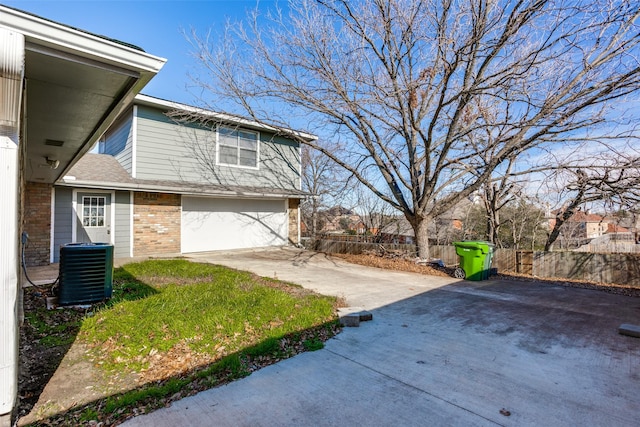 view of property exterior featuring a garage and central AC