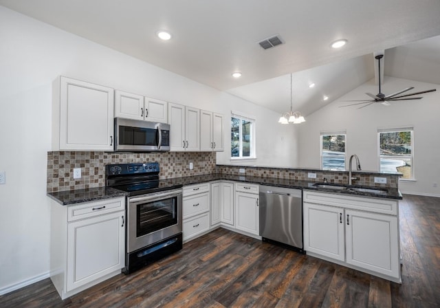 kitchen with ceiling fan with notable chandelier, stainless steel appliances, sink, lofted ceiling with beams, and white cabinets