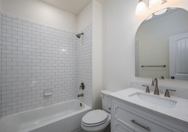 full bathroom featuring tiled shower / bath combo, toilet, and vanity