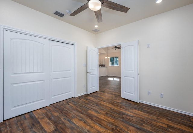 unfurnished bedroom featuring ceiling fan, dark hardwood / wood-style flooring, and a closet