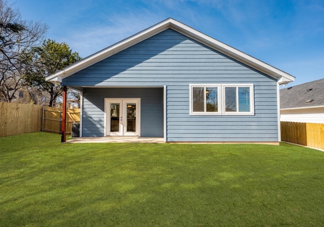 rear view of property with french doors and a lawn