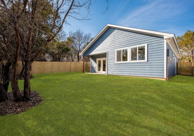 back of house featuring french doors and a lawn