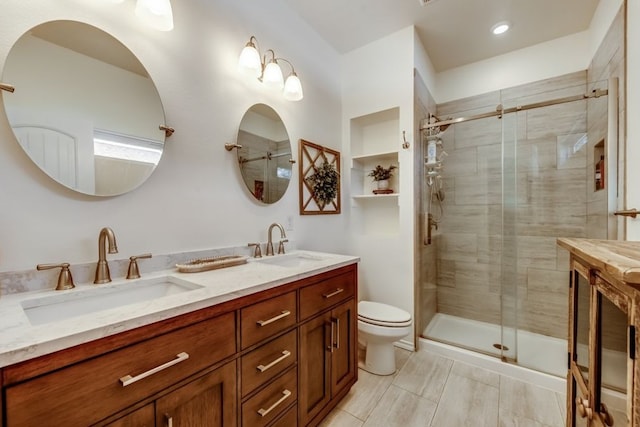 bathroom featuring vanity, toilet, and a shower with shower door