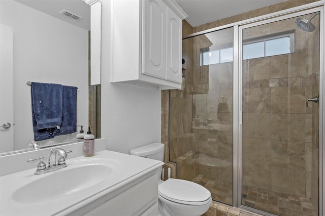 bathroom featuring visible vents, vanity, toilet, and a shower stall