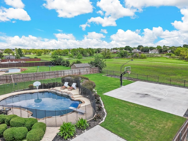 view of pool featuring a yard and basketball court