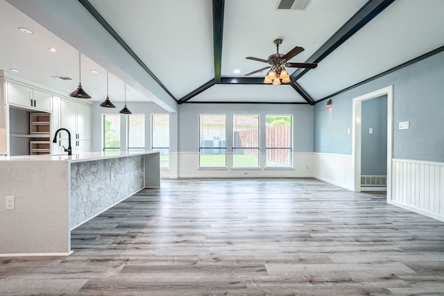 unfurnished living room featuring ornamental molding, plenty of natural light, ceiling fan, and lofted ceiling