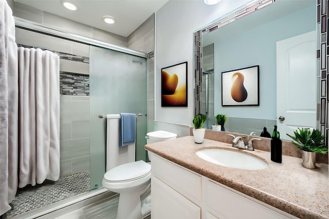 bathroom featuring an enclosed shower, vanity, and toilet