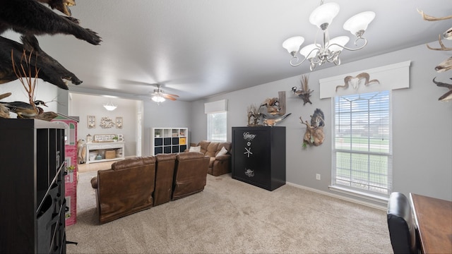 carpeted living room with ceiling fan with notable chandelier