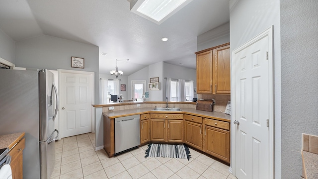 kitchen with an inviting chandelier, hanging light fixtures, lofted ceiling, and appliances with stainless steel finishes