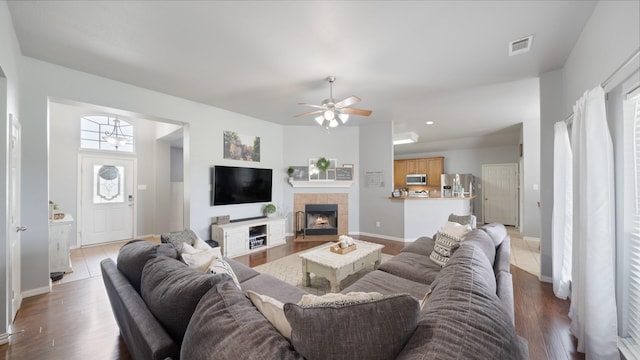 living room featuring a fireplace, light wood-type flooring, and ceiling fan