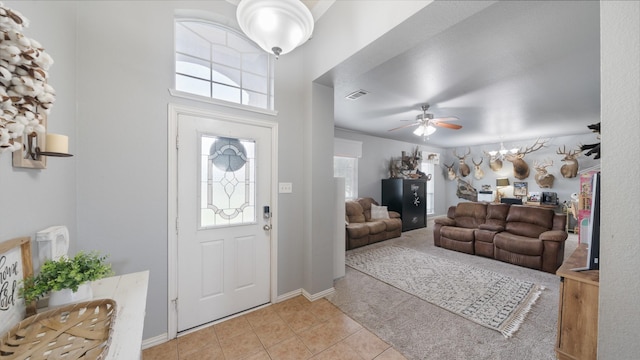 entryway featuring light tile patterned floors, a wealth of natural light, and ceiling fan