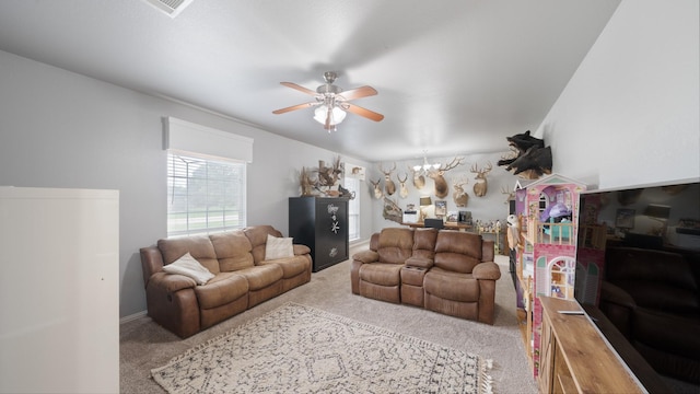 carpeted living room featuring ceiling fan with notable chandelier