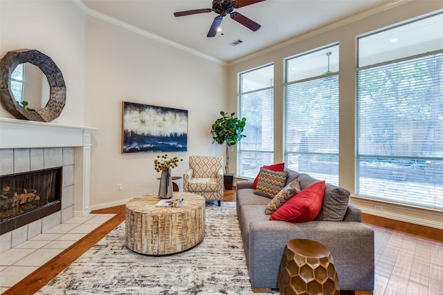 living room featuring hardwood / wood-style floors, a fireplace, ornamental molding, and ceiling fan