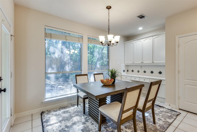 tiled dining room with an inviting chandelier