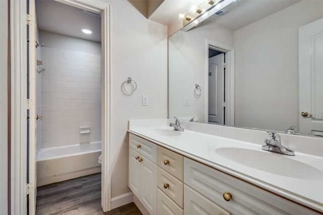 full bathroom with vanity, tiled shower / bath combo, wood-type flooring, and toilet