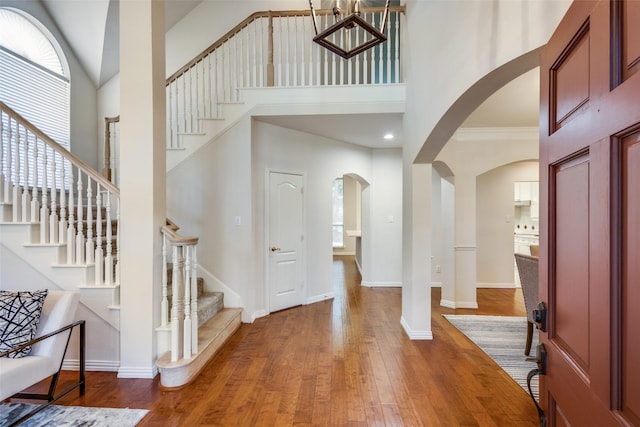 entryway featuring wood-type flooring and a high ceiling