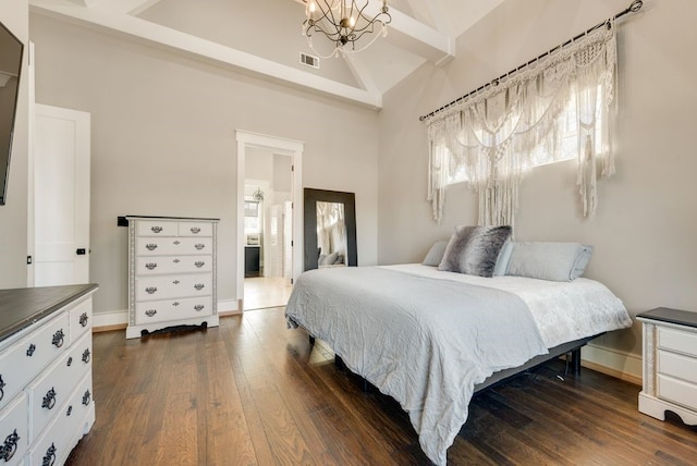 bedroom featuring dark wood-type flooring, ensuite bath, a chandelier, and high vaulted ceiling