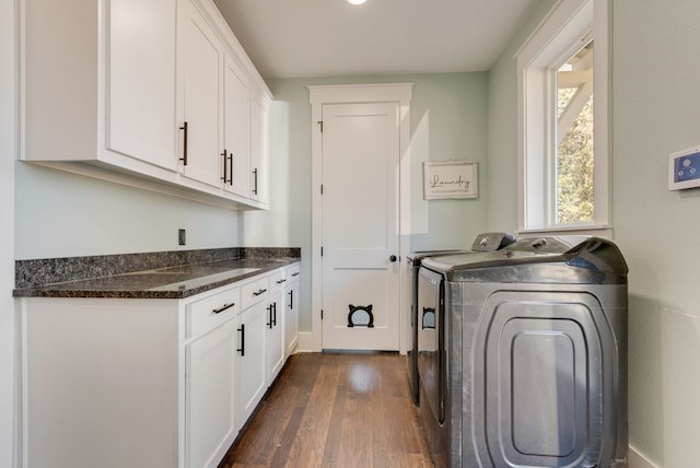 clothes washing area with cabinets, dark hardwood / wood-style floors, and washer and clothes dryer