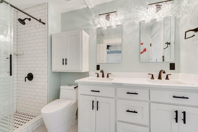 bathroom with vanity, tiled shower, and toilet