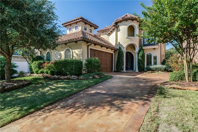 mediterranean / spanish-style house featuring a front yard and a garage