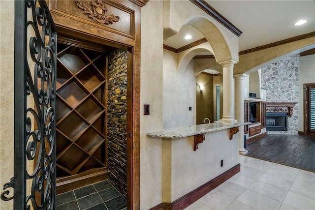 wine area featuring ornate columns and ornamental molding