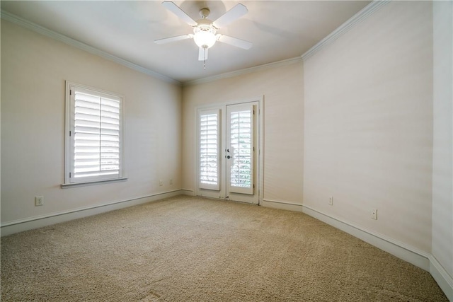 spare room featuring ceiling fan, light colored carpet, and ornamental molding