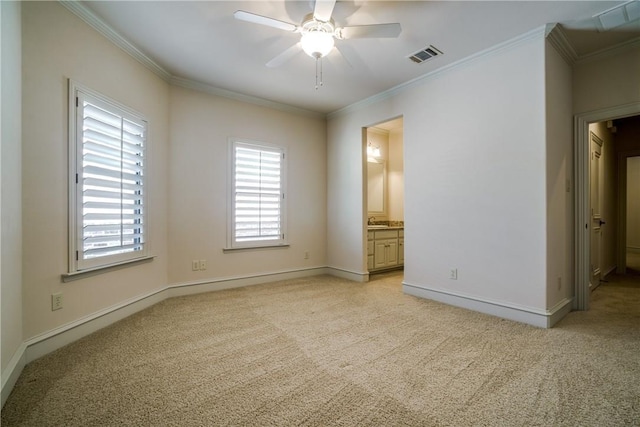 unfurnished bedroom with ceiling fan, light colored carpet, ornamental molding, and ensuite bath