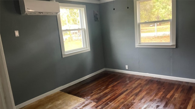 empty room with a wall unit AC and dark wood-type flooring