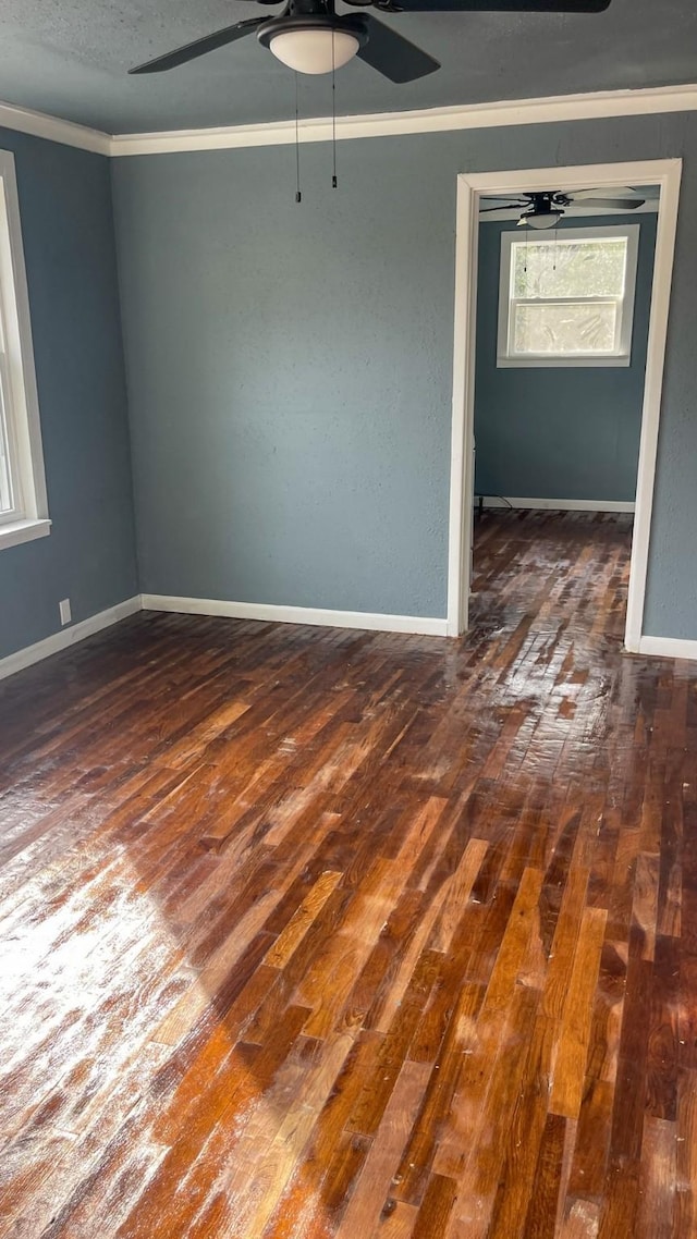 unfurnished room featuring dark hardwood / wood-style flooring, ornamental molding, and ceiling fan