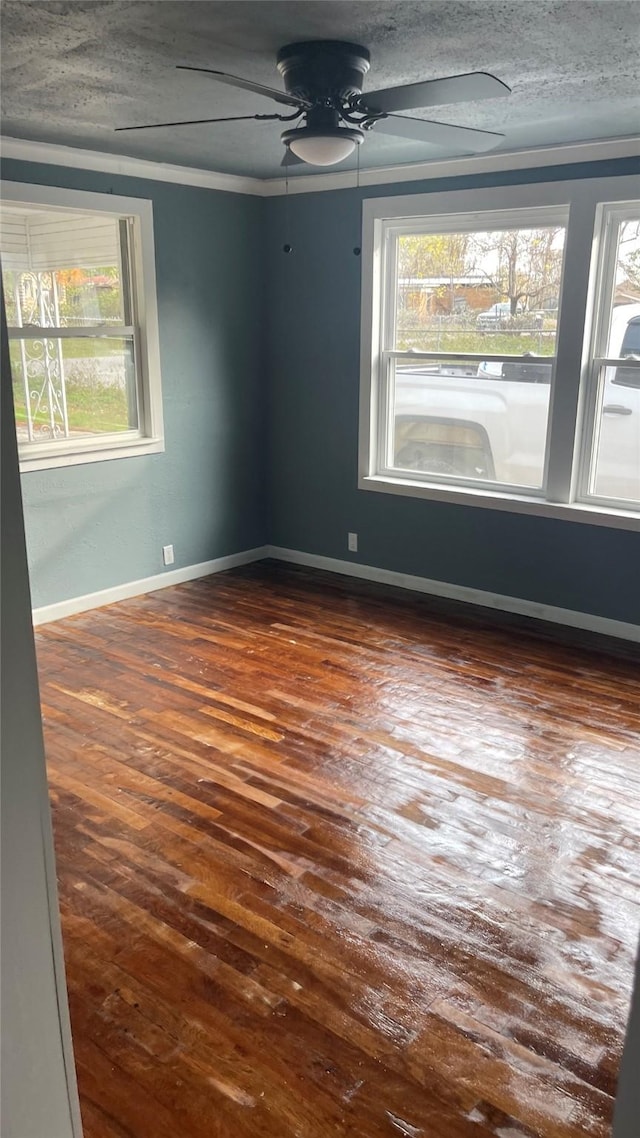 spare room with dark hardwood / wood-style flooring, ornamental molding, and a wealth of natural light