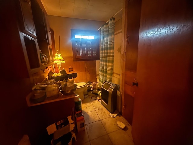 bathroom with tile patterned flooring, curtained shower, and toilet