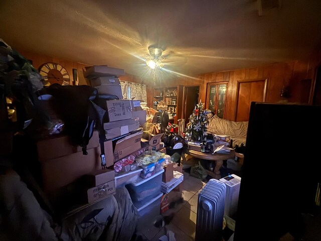 miscellaneous room featuring ceiling fan, radiator heating unit, and wooden walls