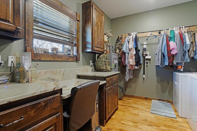 laundry area featuring cabinets, washer and clothes dryer, and light hardwood / wood-style floors